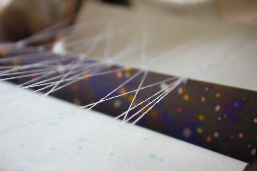 a close up shot of a spread from the book that uses string for a physical manifestation of the author's network activity.