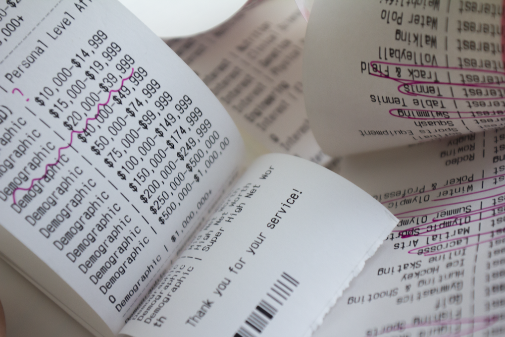 a close up shot of a spread from the book that has personal data collected from ad companies printed out on receipt paper.